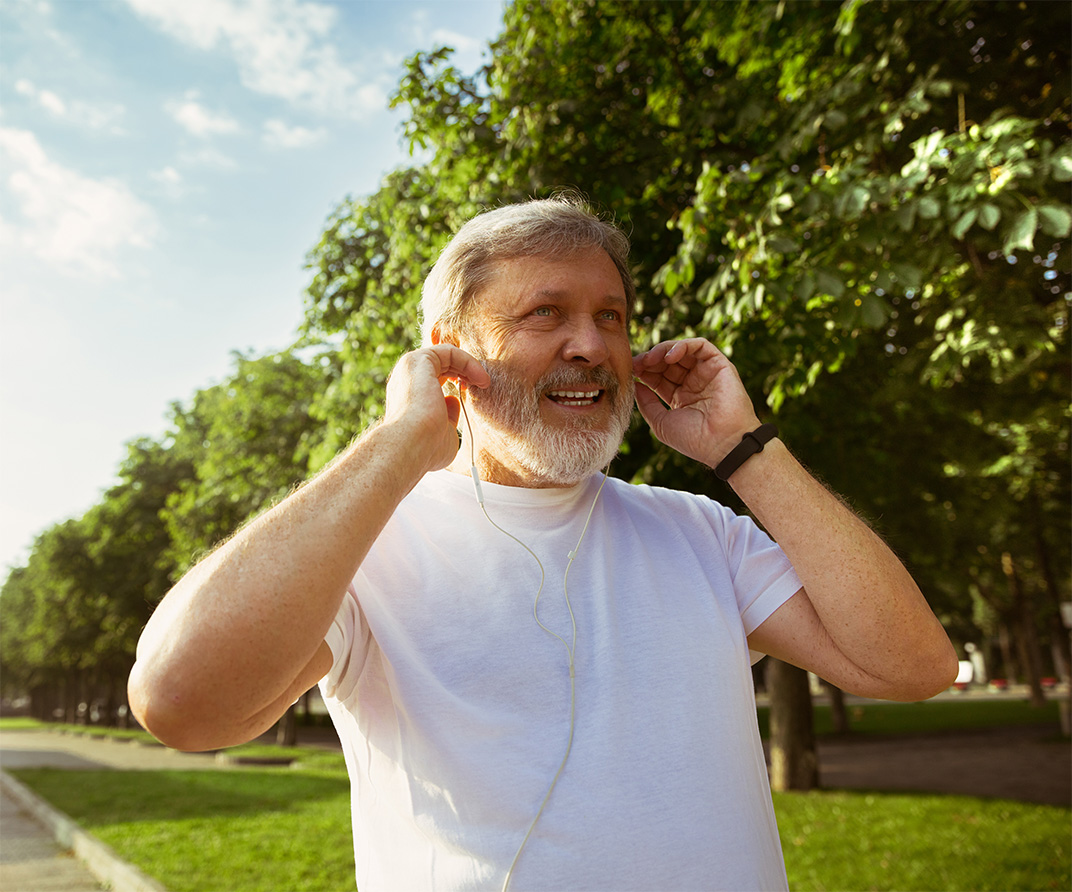 Senior men exercising with earphones.